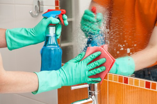 Cleaner carrying out safe cleaning procedures with protective equipment